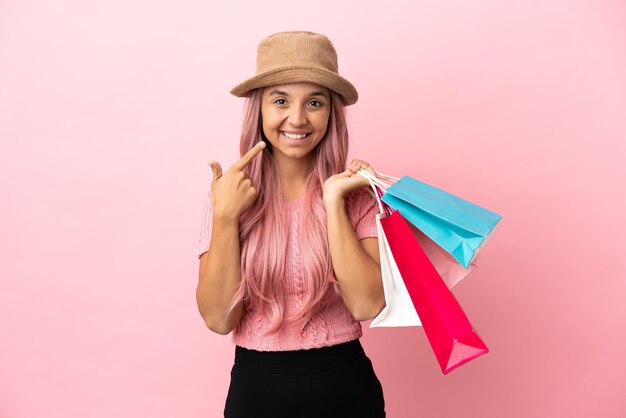 Jeune femme métisse avec panier isolé sur fond rose donnant un geste du pouce vers le haut