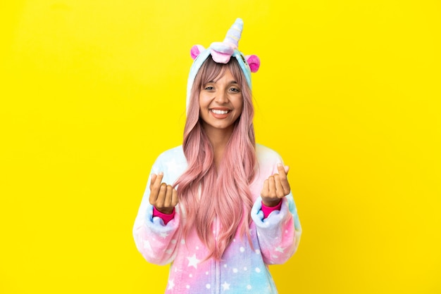 Photo jeune femme métisse portant un pyjama licorne isolé sur fond blanc faisant un geste d'argent