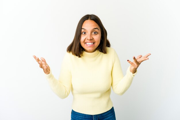 Photo jeune femme métisse recevant une agréable surprise, excitée et levant les mains.