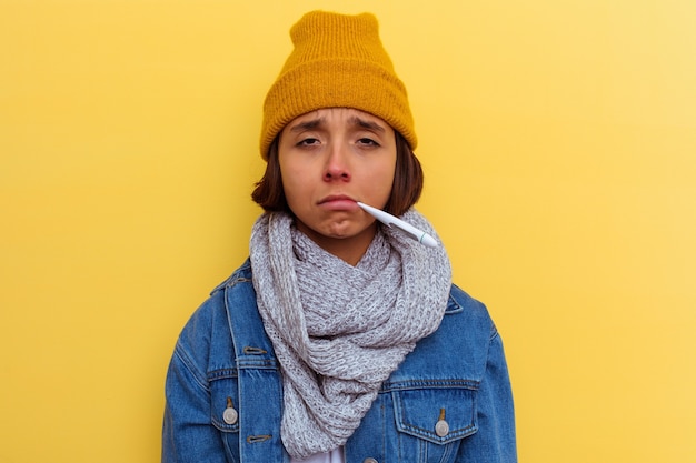 Jeune femme métisse avec un rhume sur mur jaune