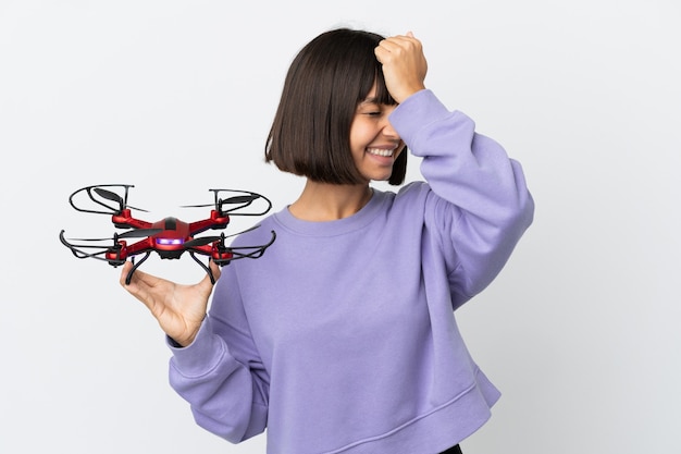 Photo jeune femme métisse tenant un drone isolé sur fond blanc a réalisé quelque chose et a l'intention de la solution