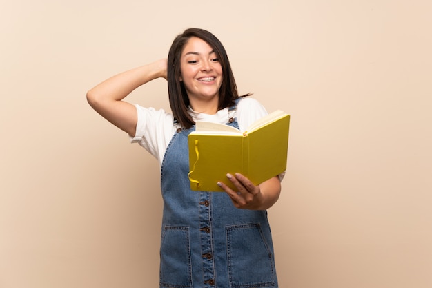 Jeune femme mexicaine sur fond isolé tenant et en lisant un livre