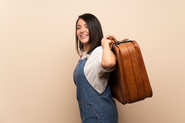 Jeune femme mexicaine sur isolé tenant une mallette vintage