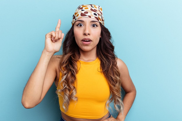 Jeune femme mexicaine isolée sur fond bleu ayant une idée, concept d'inspiration.