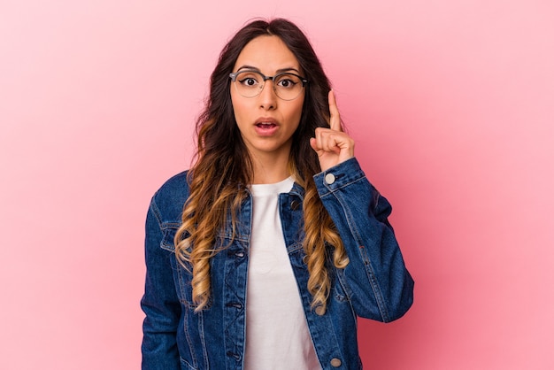 Jeune femme mexicaine isolée sur fond rose ayant une idée, un concept d'inspiration.