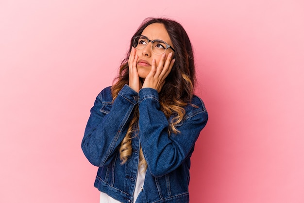 Jeune femme mexicaine isolée sur mur rose pleurnichant et pleurant de façon inconsolable.