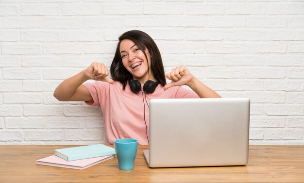 Jeune femme mexicaine avec un ordinateur portable fier et satisfait