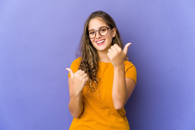 Jeune femme mignonne caucasienne, levant les deux pouces vers le haut, souriante et confiante.