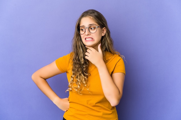 Jeune femme mignonne caucasienne touchant l'arrière de la tête, pensant et faisant un choix.