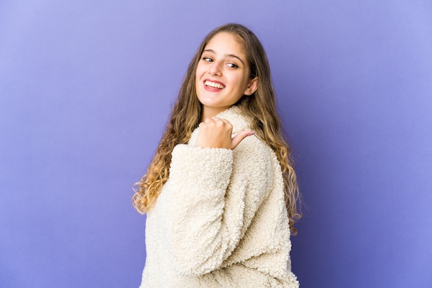 Jeune femme mignonne pointe avec le pouce, riant et insouciant