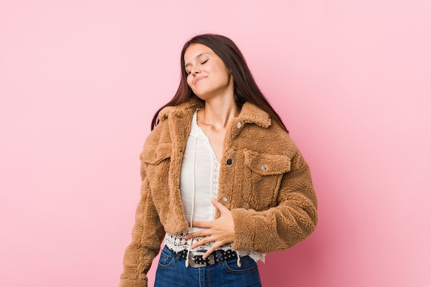 Jeune femme mignonne touche le ventre, sourit doucement, concept de manger et de satisfaction.