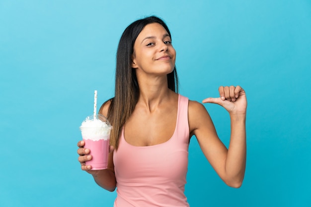 Jeune femme avec milk-shake aux fraises fier et satisfait de soi