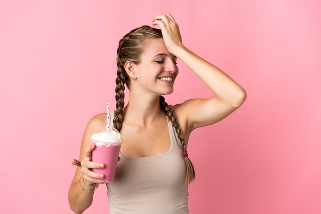 Jeune femme avec milkshake aux fraises isolé sur mur rose a réalisé quelque chose et l'intention de la solution