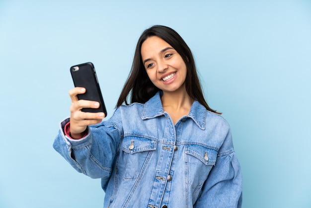 Jeune, femme, mobile, isolé, mur