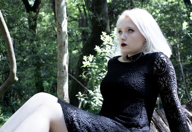 Photo une jeune femme à la mode assise dans la forêt