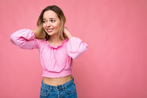 Jeune femme à la mode belle femme en haut court rose à la mode femme positive montre du visage