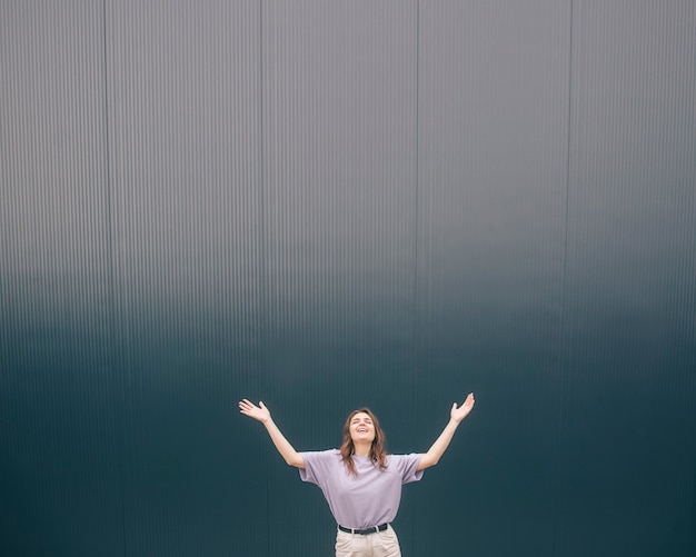 Jeune femme à la mode élégante regardant et se tenant la main dans l'air