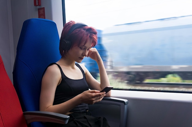 Jeune femme monte dans un train immergé dans un smartphone