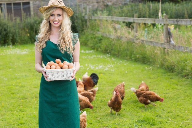 Jeune femme montrant un panier rempli d&#39;oeufs