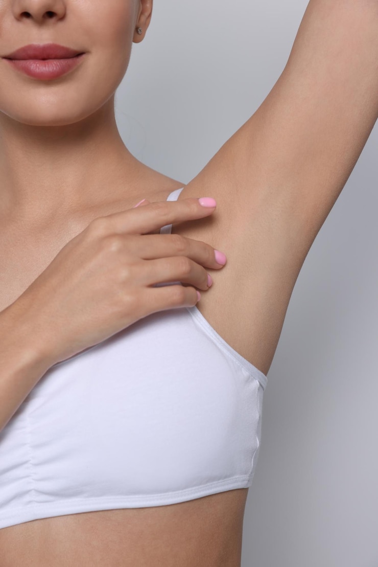 Photo jeune femme montrant une peau lisse après épilation sur fond blanc gros plan