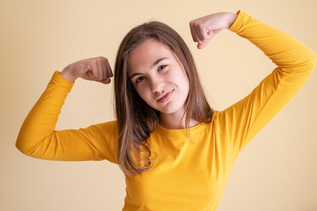 Jeune femme montrant ses bicesp, concept de femme puissante, la force des femmes.