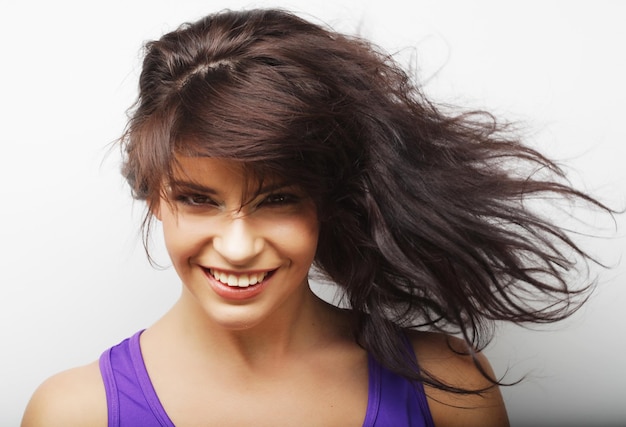 Jeune femme avec mouvement de cheveux sur fond blanc