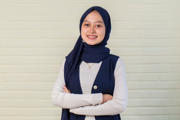 Jeune femme musulmane asiatique en foulard de tête sourire avec les bras croisés