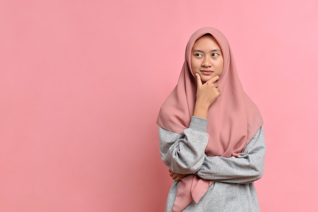 Jeune Femme Musulmane Asiatique Regardant Un Espace De Copie Ou Pensant à Une Idée ; Isolé Sur Fond Rose