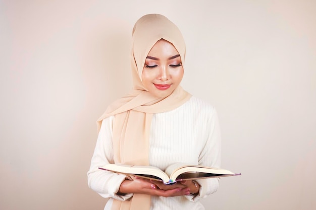 Jeune femme musulmane asiatique souriant et tenant le Coran