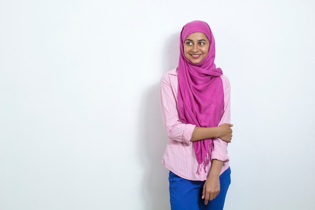 Une jeune femme musulmane heureuse en hijab sur fond blanc. Espace copie
