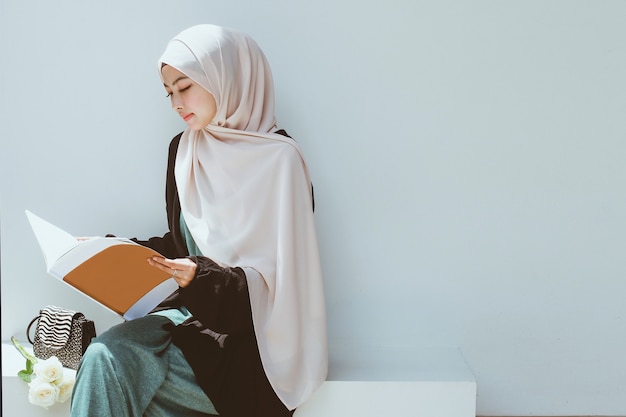 Jeune femme musulmane lisant un livre