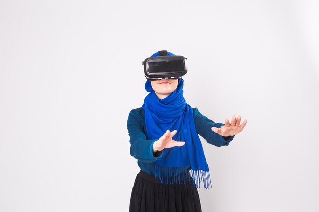 Jeune femme musulmane avec des lunettes de réalité virtuelle. Concept de technologie, de réalité virtuelle, d'avenir et de personnes.