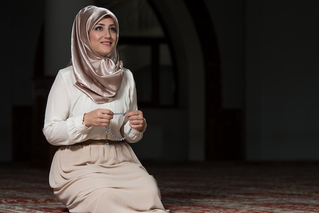 Jeune femme musulmane priant dans la mosquée