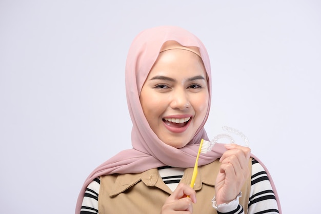 Une jeune femme musulmane utilisant une brosse à dents avec de belles dents Concept de soins de santé dentaire