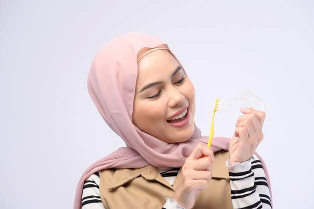 Une jeune femme musulmane utilisant une brosse à dents avec de belles dents Concept de soins de santé dentaire