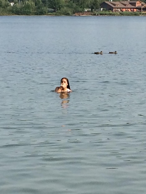 Photo une jeune femme nageant dans le lac.