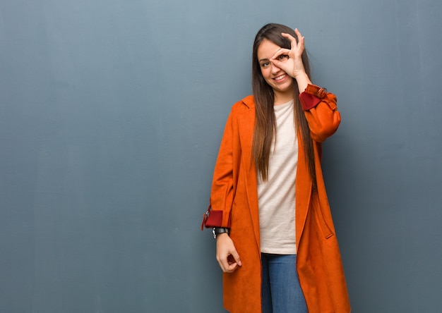 Jeune femme naturelle confiante faisant un geste ok sur l'oeil