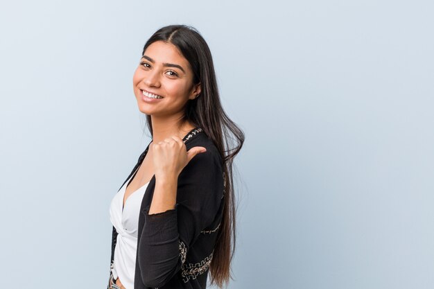 Jeune femme naturelle et jolie arabe pointe avec le pouce