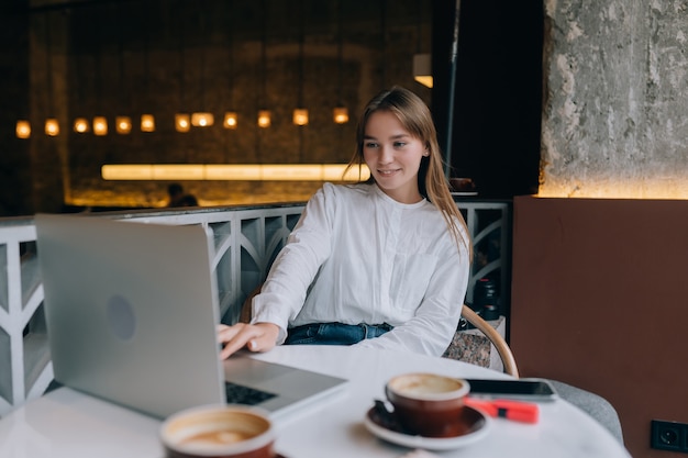 Jeune femme naviguant sur Internet au café