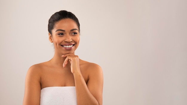 Une jeune femme noire belle et joyeuse qui regarde l'espace de copie.