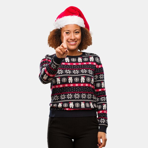 Jeune femme noire dans un pull de Noël à la mode avec une impression du numéro un