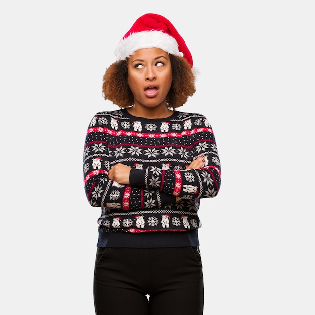 Jeune femme noire dans un pull de Noël à la mode avec une impression fatiguée et ennuyée