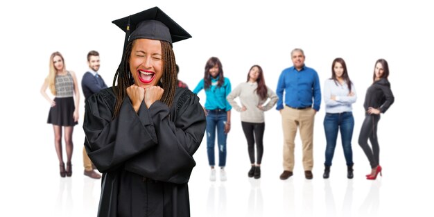 Photo jeune femme noire diplômée portant des tresses très heureuse et excitée, levant les bras