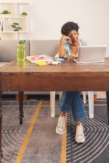 Photo jeune femme noire écoutant sa classe virtuelle