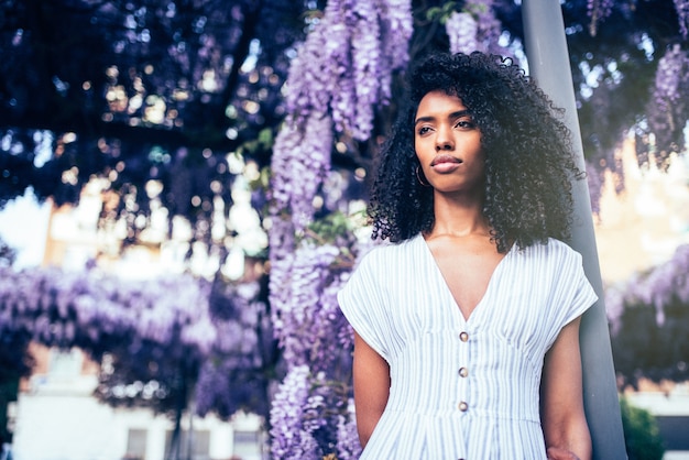 Jeune femme noire entourée de fleurs