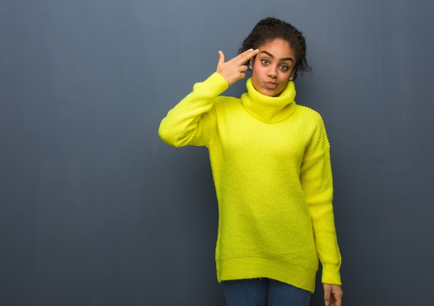 Jeune femme noire faisant un geste de suicide