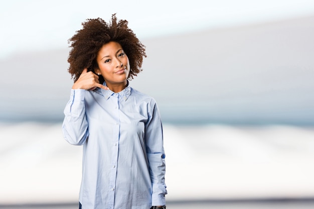 jeune femme noire faisant le geste de téléphone