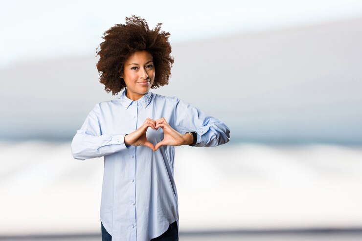 Photo jeune femme noire faisant le symbole du coeur
