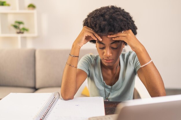 Jeune femme noire fatiguée d'étudier ses notes