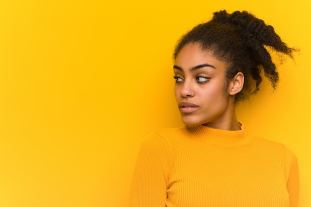 Jeune femme noire gros plan sur un mur orange